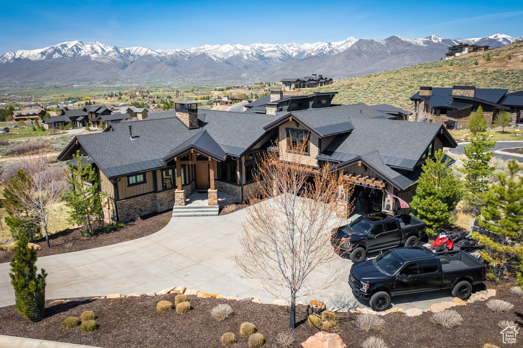 View of front of house featuring stone siding, board and batten siding, a porch, a mountain view, and roof with shingles