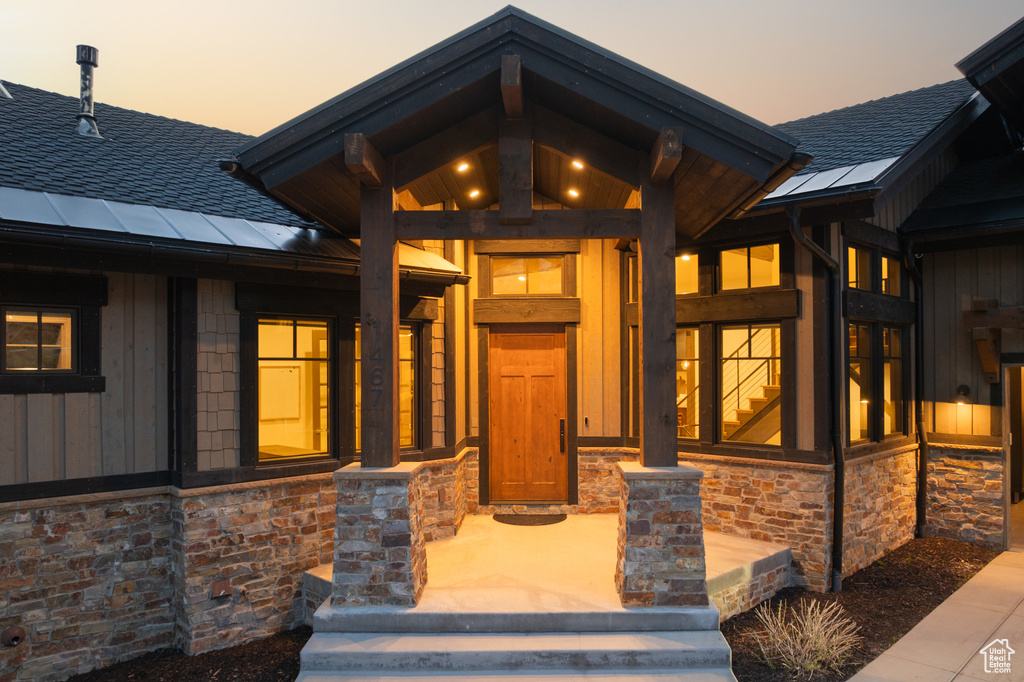 Exterior entry at dusk with stone siding