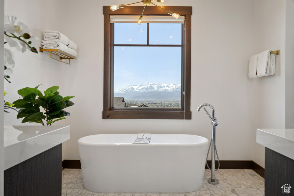 Full bathroom featuring healthy amount of natural light and a soaking tub