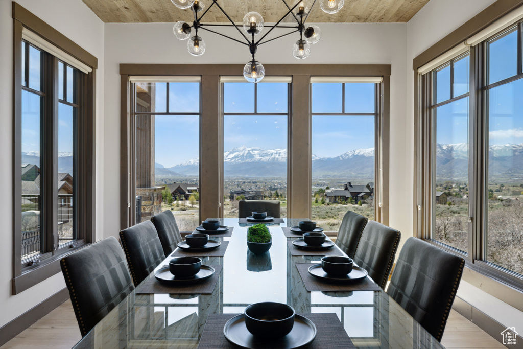 Dining area with a mountain view, a chandelier, and light wood-style flooring