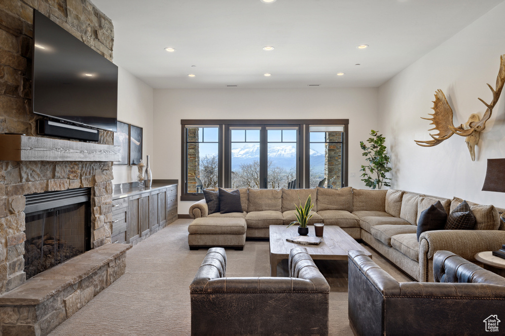 Living area featuring carpet, a stone fireplace, and recessed lighting