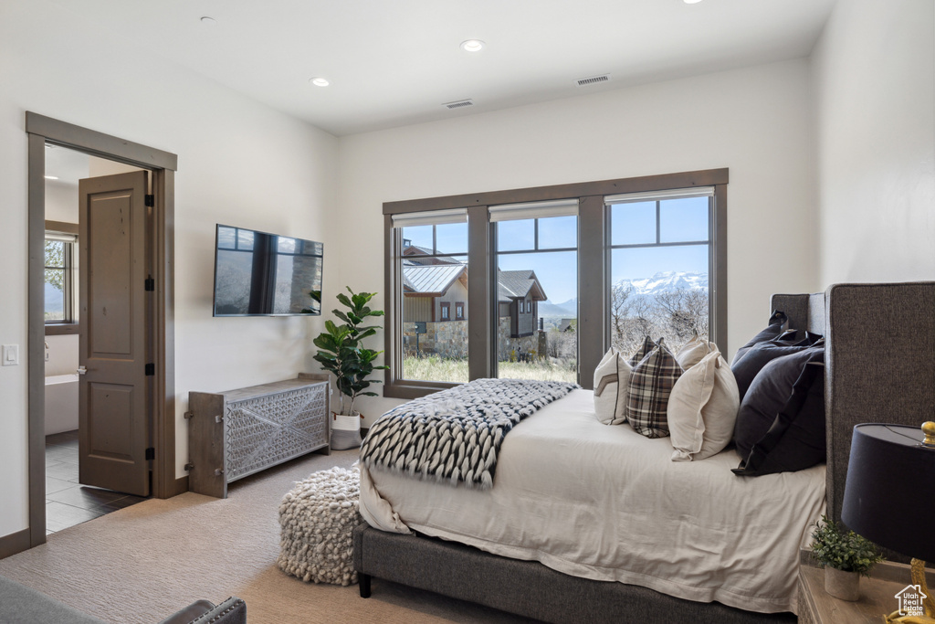 Carpeted bedroom with multiple windows and recessed lighting