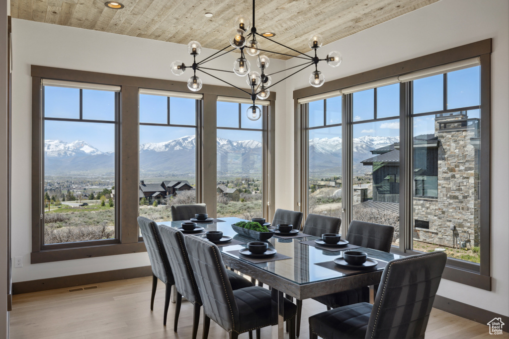Dining space with a chandelier, wooden ceiling, light wood-type flooring, and a mountain view