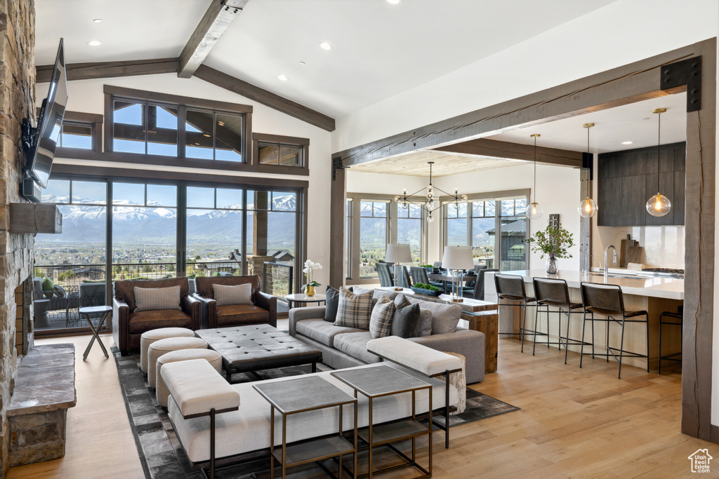 Living area featuring beam ceiling, light wood-style flooring, a chandelier, recessed lighting, and high vaulted ceiling