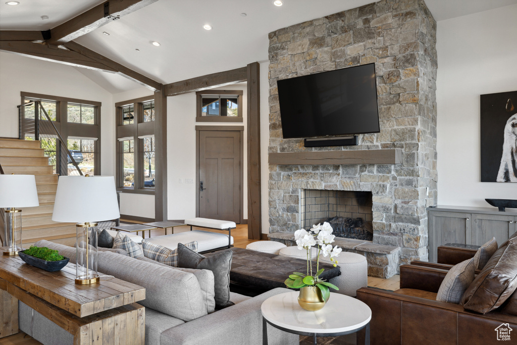 Living room with stairway, a fireplace, beam ceiling, wood finished floors, and recessed lighting