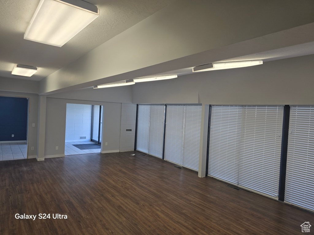 Spare room featuring wood finished floors and lofted ceiling