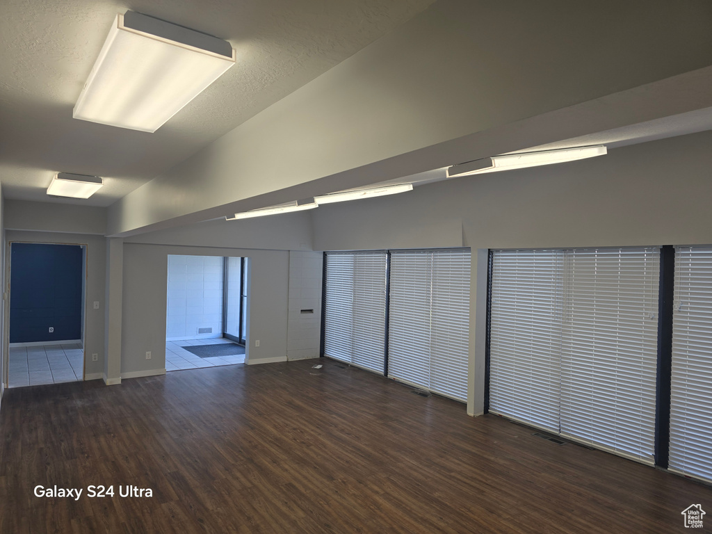 Empty room featuring wood finished floors and lofted ceiling