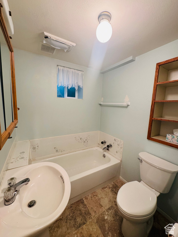 Full bathroom featuring a bath and stone finish floors