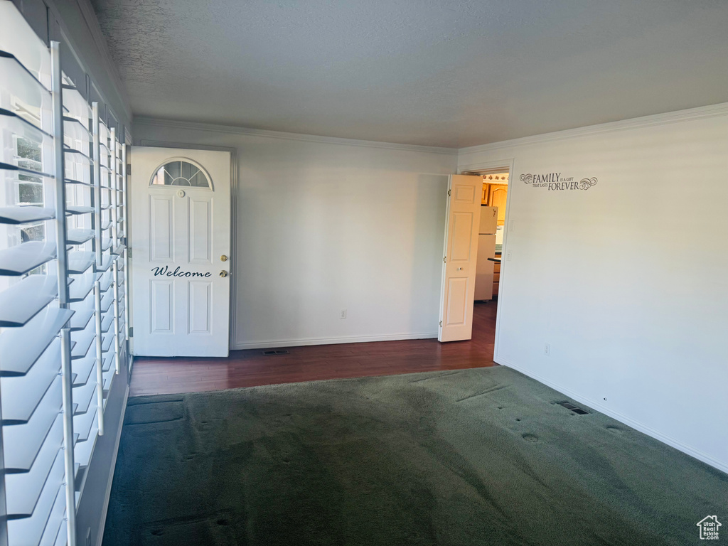 Empty room featuring ornamental molding and wood finished floors