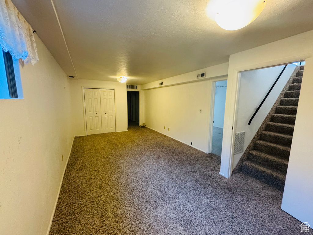 Basement featuring stairs and carpet floors