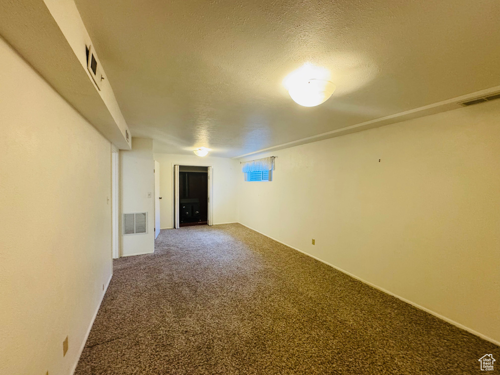 Carpeted empty room with a textured ceiling