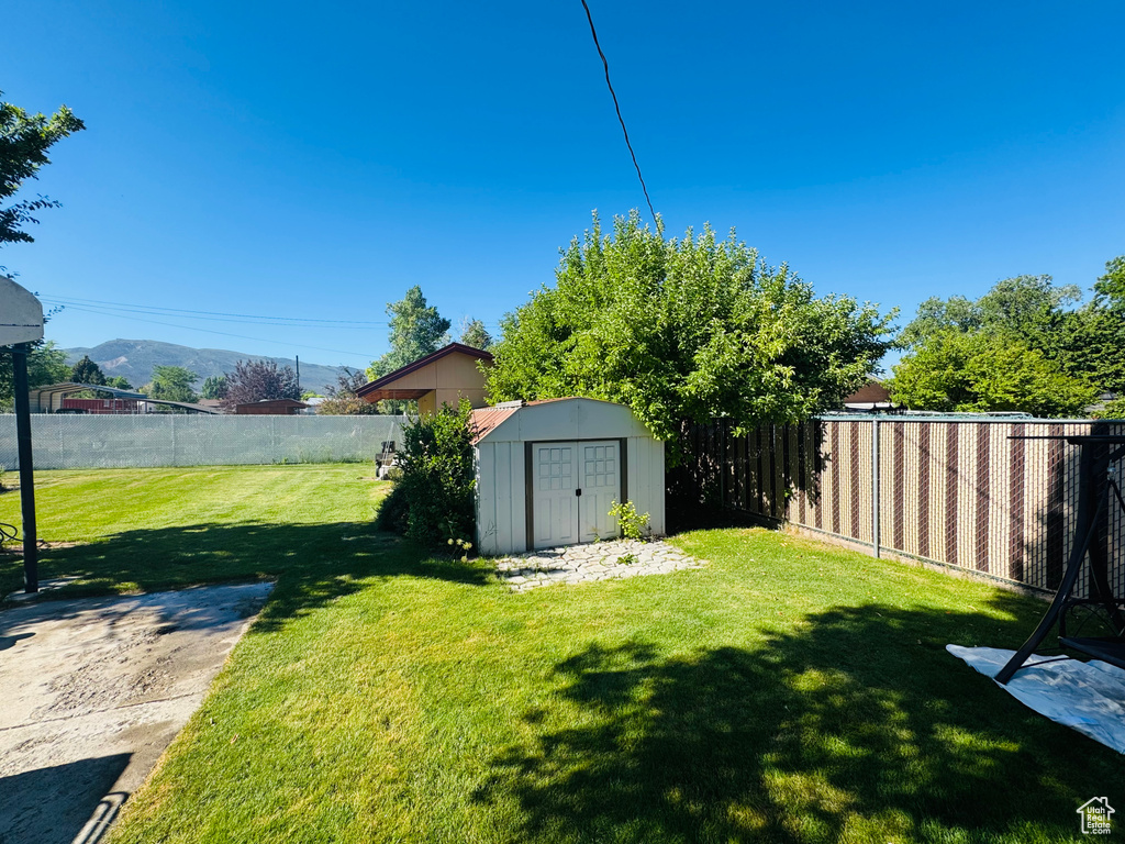 Fenced backyard with a storage shed and a mountain view