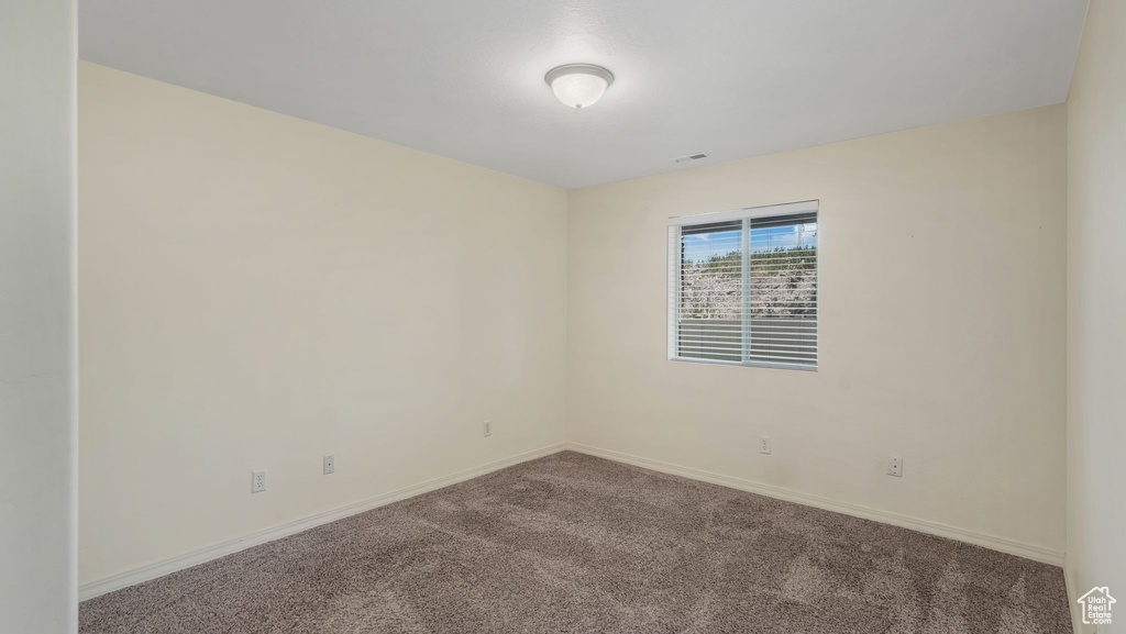 Carpeted empty room featuring baseboards