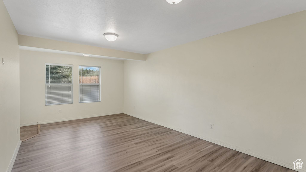 Unfurnished room with wood finished floors and baseboards