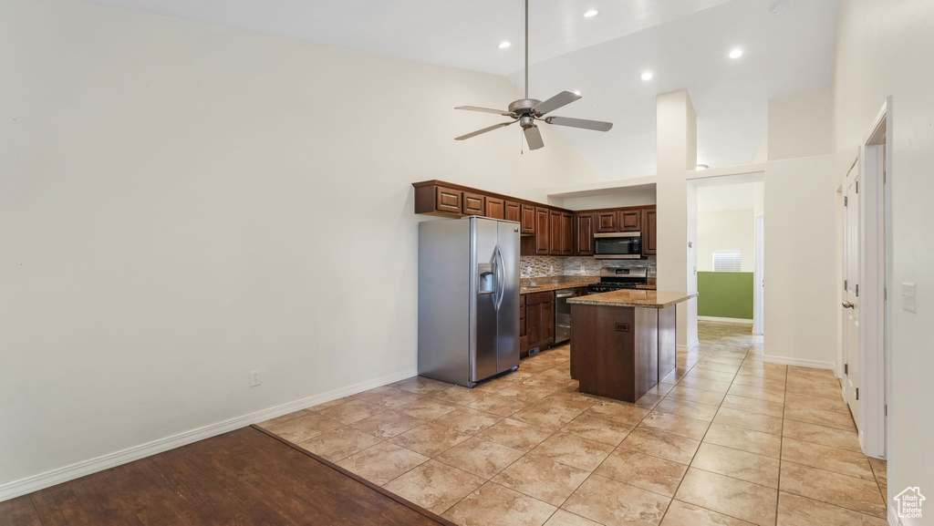 Kitchen with stainless steel appliances, ceiling fan, a center island, backsplash, and recessed lighting