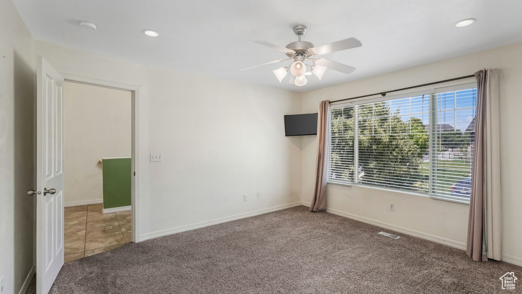 Spare room featuring carpet floors, a smoke detector, ceiling fan, and recessed lighting