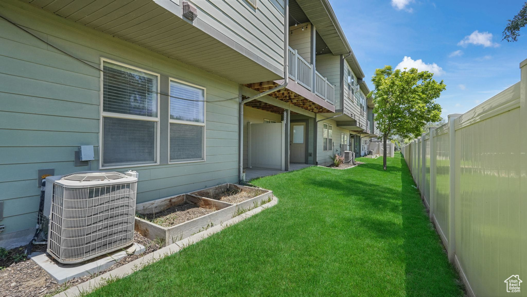 View of yard featuring a balcony and a vegetable garden