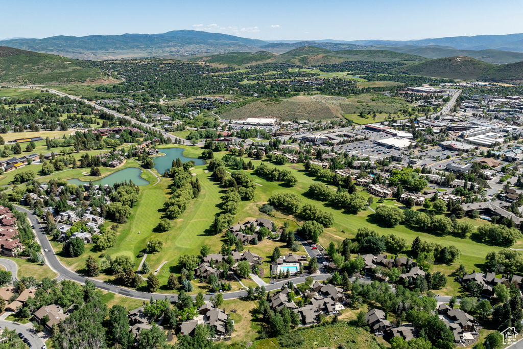 Aerial view of property and surrounding area with a water and mountain view and nearby suburban area