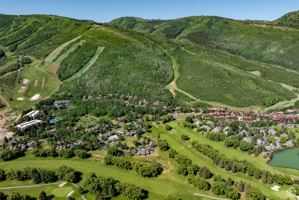 Aerial overview of property's location featuring nearby suburban area, a golf club, and a water and mountain view