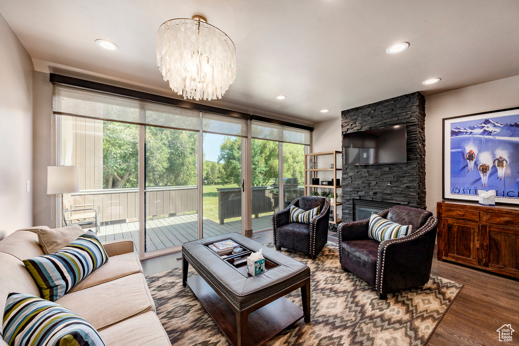 Living room with wood finished floors, a chandelier, healthy amount of natural light, recessed lighting, and a fireplace