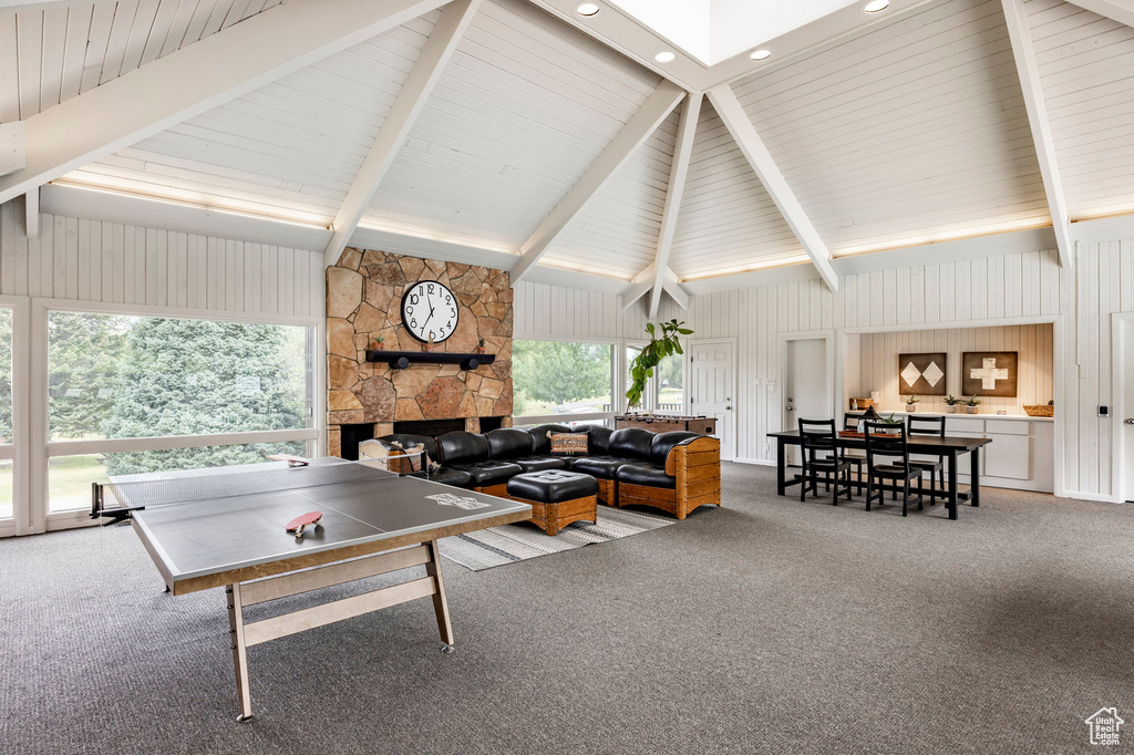 Rec room with carpet, a fireplace, beam ceiling, high vaulted ceiling, and recessed lighting