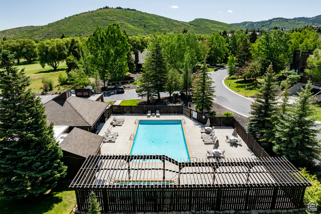 Community pool featuring a mountain view and a patio
