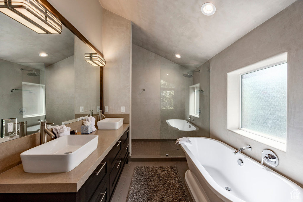 Bathroom with double vanity, walk in shower, a freestanding tub, and recessed lighting