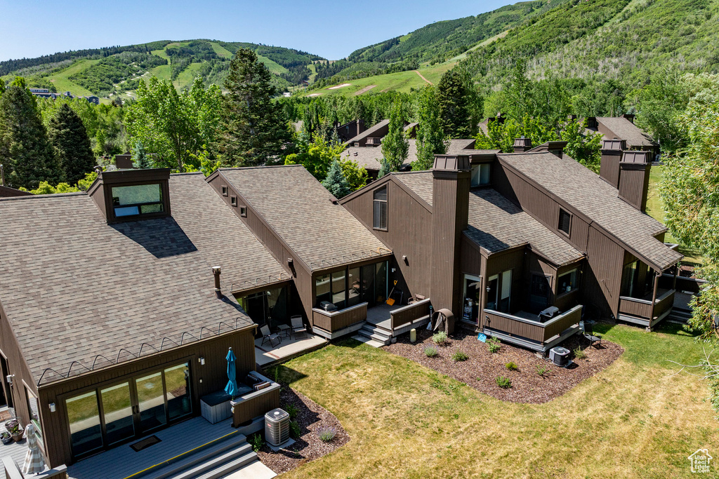 Aerial view of property and surrounding area featuring a mountainous background