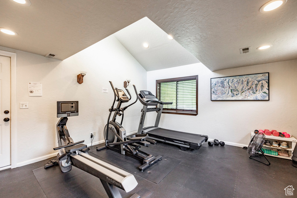 Workout room with recessed lighting, a textured ceiling, and lofted ceiling