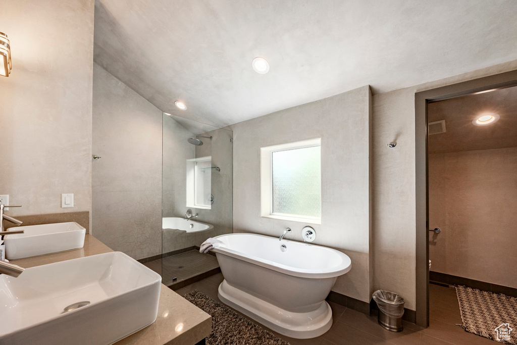 Full bath with a freestanding tub, recessed lighting, a walk in shower, double vanity, and wood finished floors