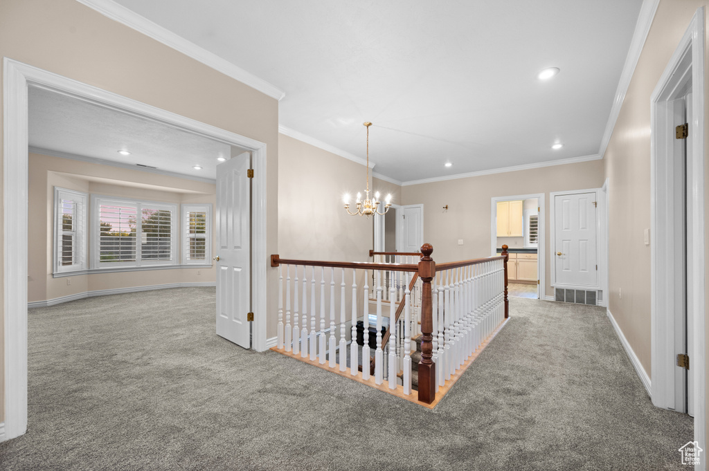 Hall featuring carpet, ornamental molding, a chandelier, recessed lighting, and an upstairs landing