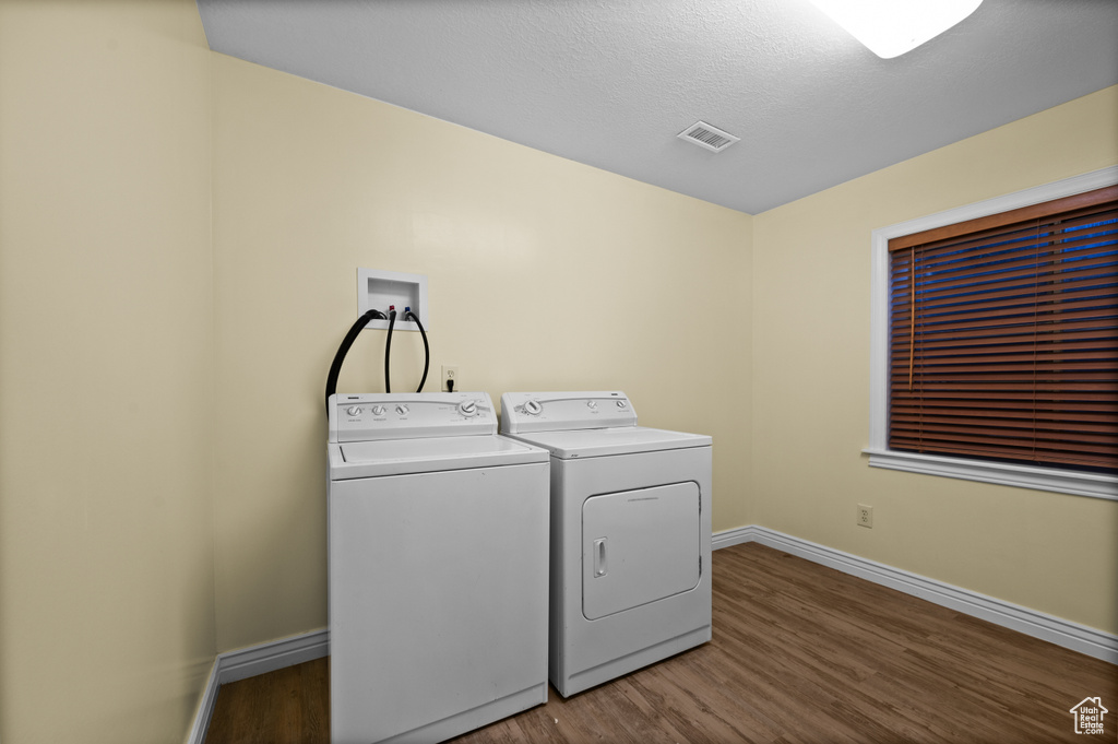 Laundry room featuring washing machine and dryer and wood finished floors