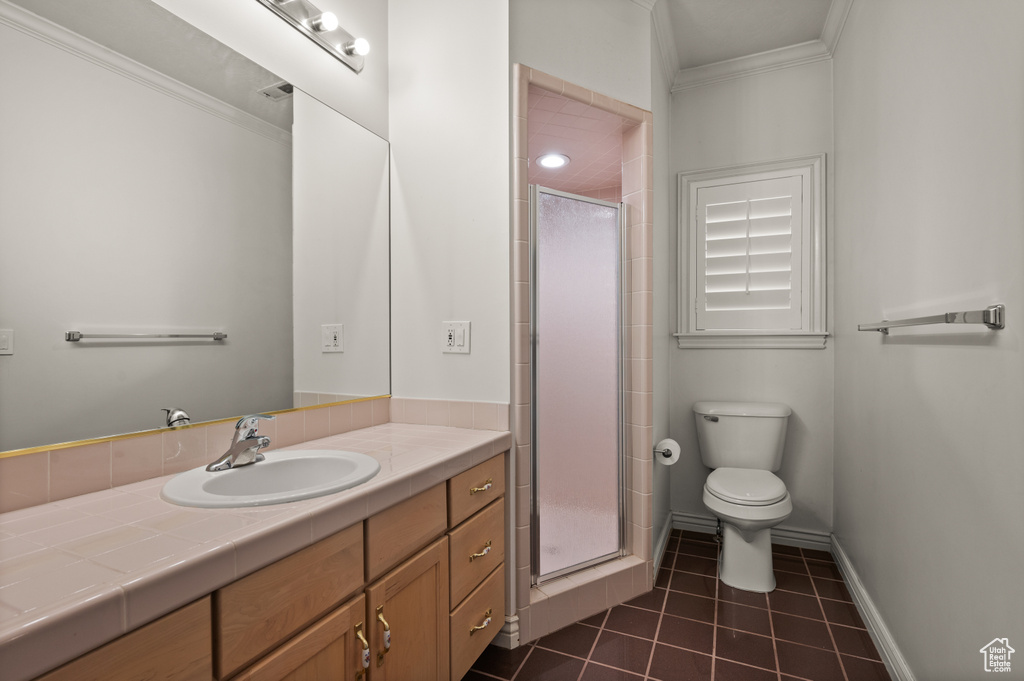 Bathroom with vanity, ornamental molding, a stall shower, and tile patterned flooring
