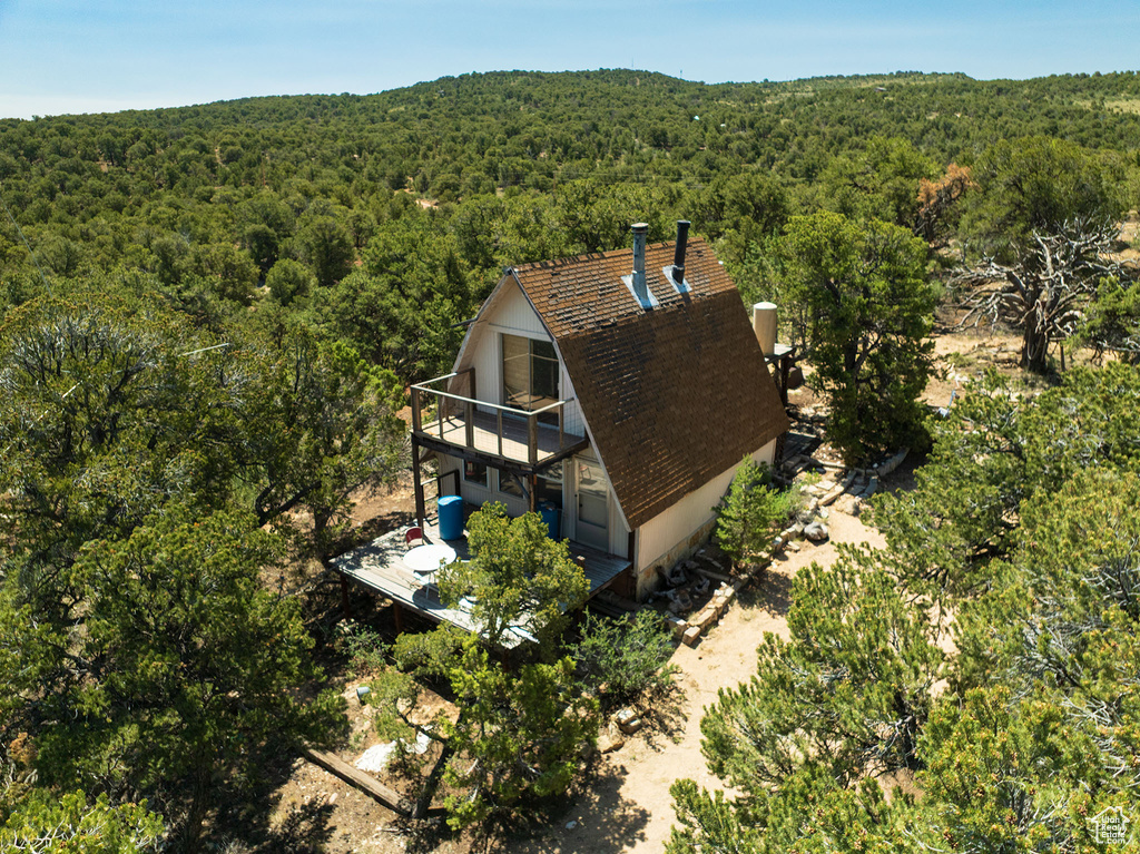 Aerial view of property and surrounding area with a forest