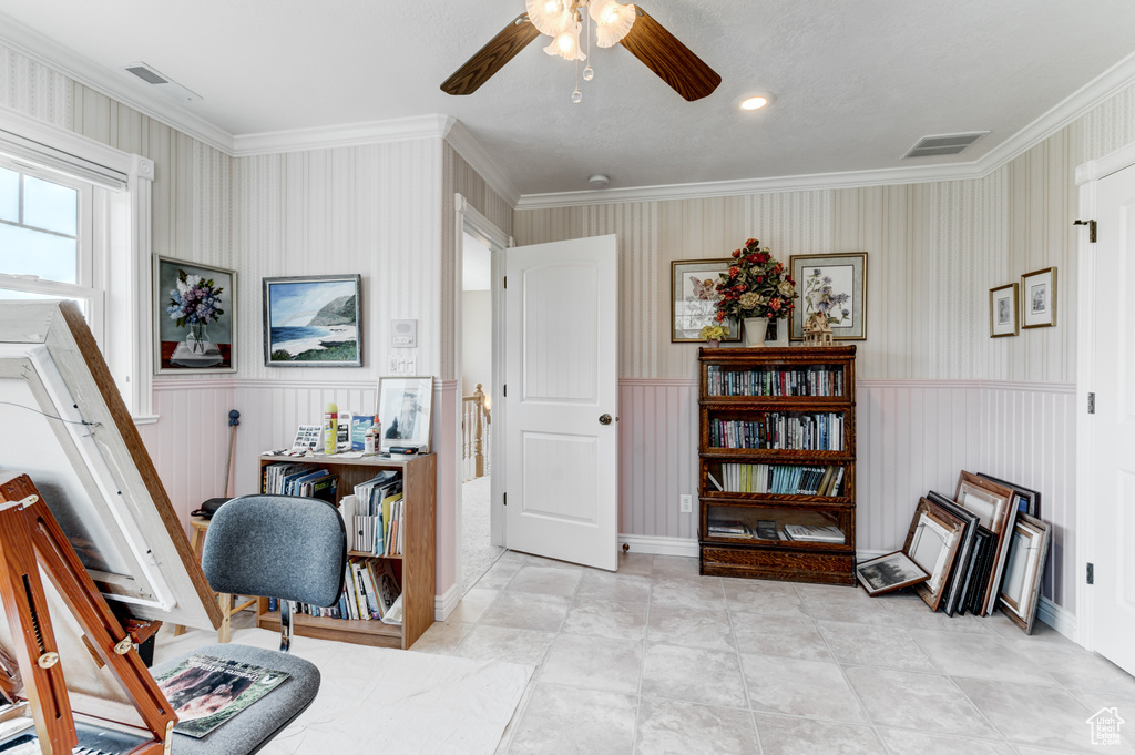 Office with ceiling fan, a wainscoted wall, crown molding, and wallpapered walls