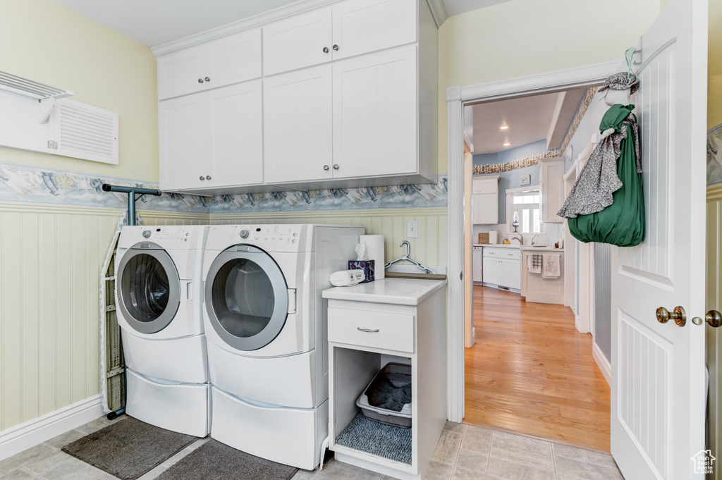 Laundry area with cabinet space and washer and clothes dryer