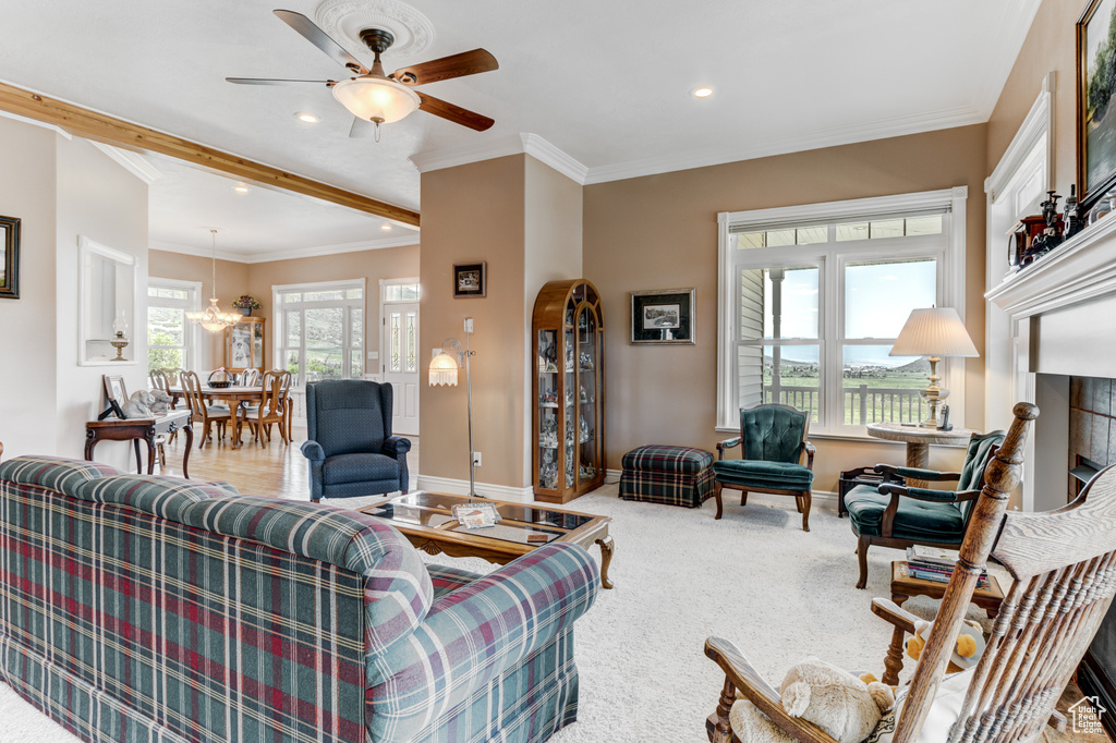 Living area with ceiling fan, recessed lighting, carpet flooring, ornamental molding, and a chandelier