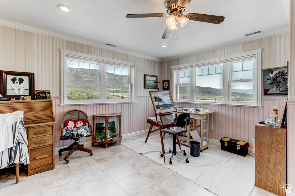 Home office with plenty of natural light, crown molding, wallpapered walls, a ceiling fan, and wainscoting