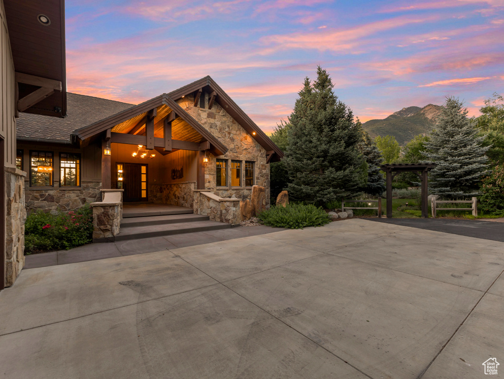 Rustic home featuring stone siding, driveway, and a mountain view