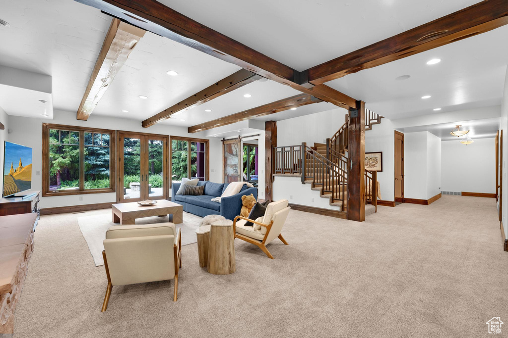 Living room with light colored carpet, recessed lighting, beam ceiling, and stairway