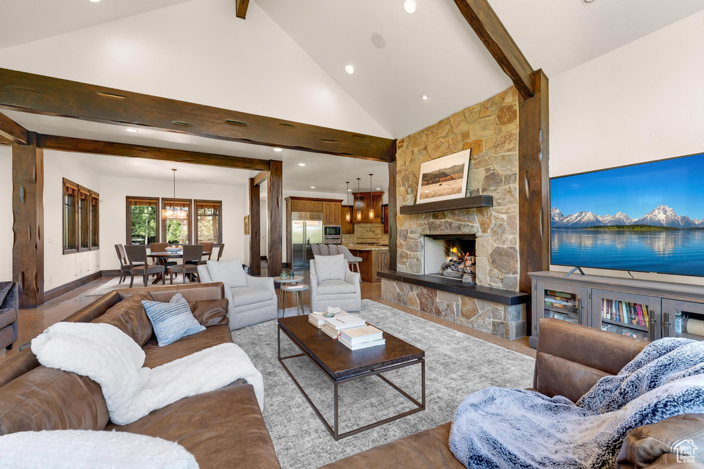 Living room featuring beam ceiling, recessed lighting, a fireplace, and high vaulted ceiling