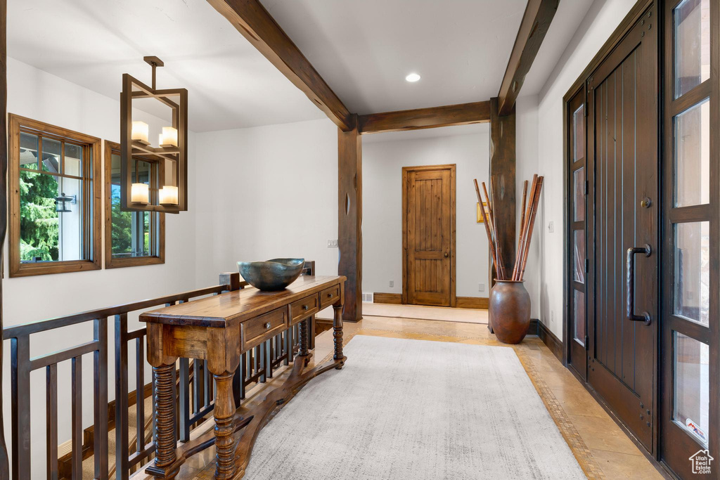 Hallway with beam ceiling, light tile patterned floors, and recessed lighting