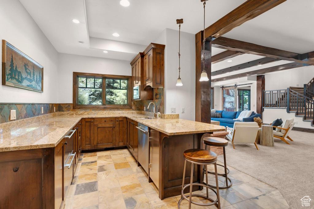 Kitchen with a peninsula, light stone counters, recessed lighting, a kitchen breakfast bar, and stainless steel dishwasher