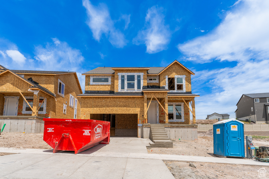 Property in mid-construction with driveway, a garage, and brick siding