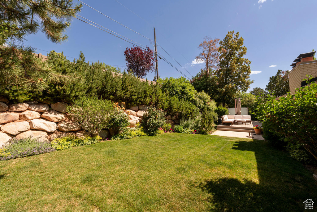 View of green lawn featuring an outdoor hangout area and a patio