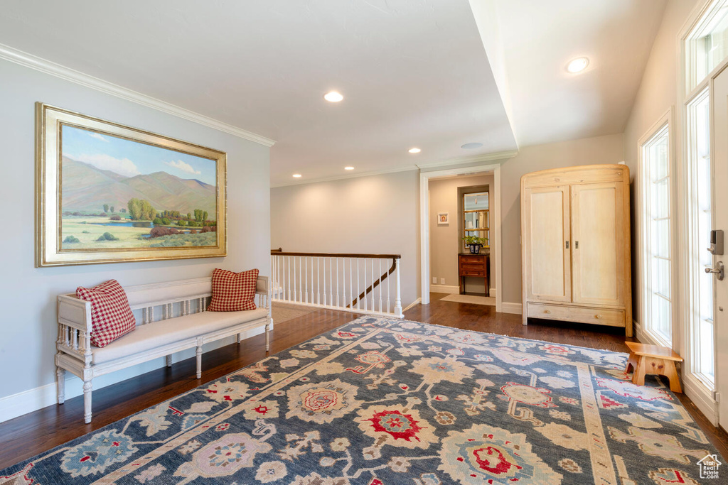 Living area featuring an upstairs landing, wood finished floors, ornamental molding, and recessed lighting