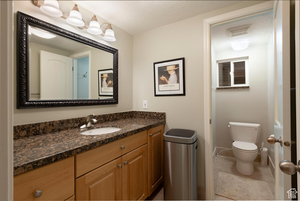 Bathroom featuring vanity, tile patterned flooring, and a textured ceiling