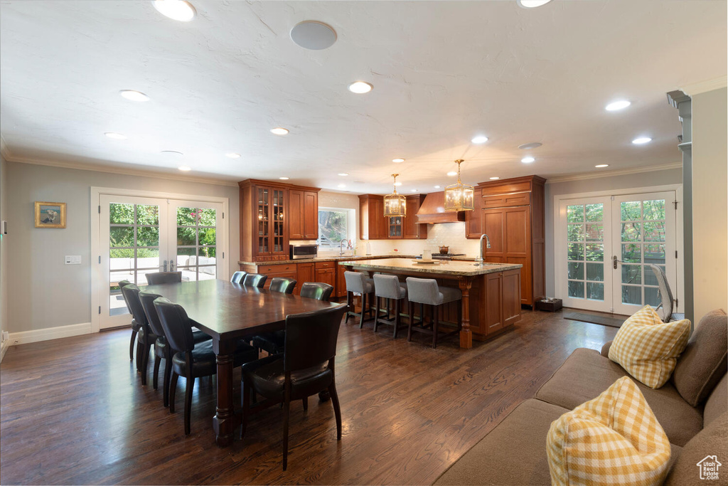 Dining space featuring french doors, ornamental molding, recessed lighting, and dark wood-style flooring
