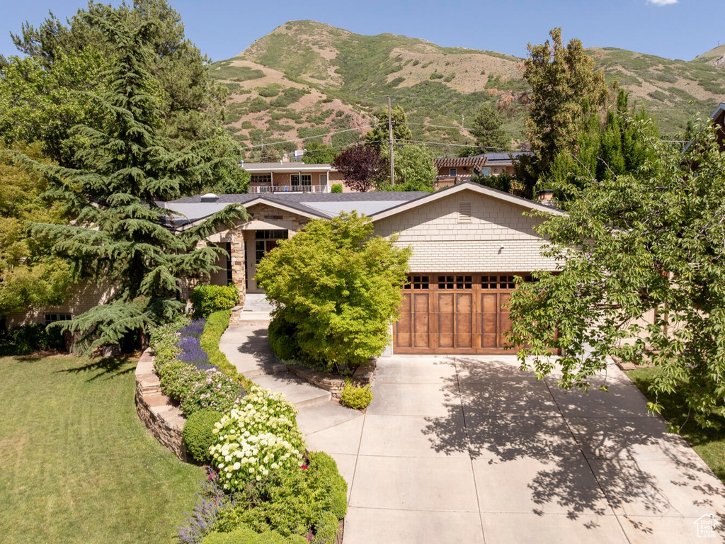 View of front facade with a garage, concrete driveway, and a mountain view
