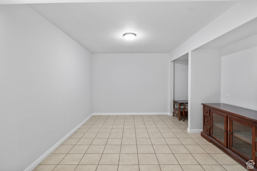 Spare room with baseboards and light tile patterned floors